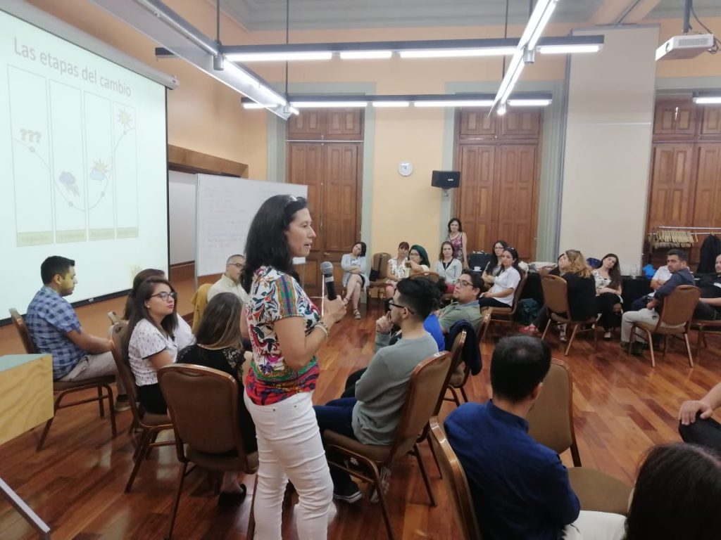 Cecilia Bertea dando instrucciones de una actividad a participantes de la Jornada inicial del Programa de Gestión del cambio UC